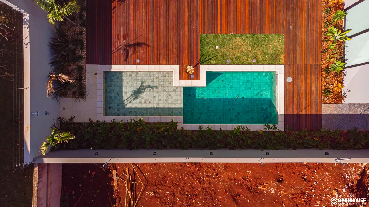Vista aérea do conjunto com faixas paralelas de deck em madeira, água e gramado