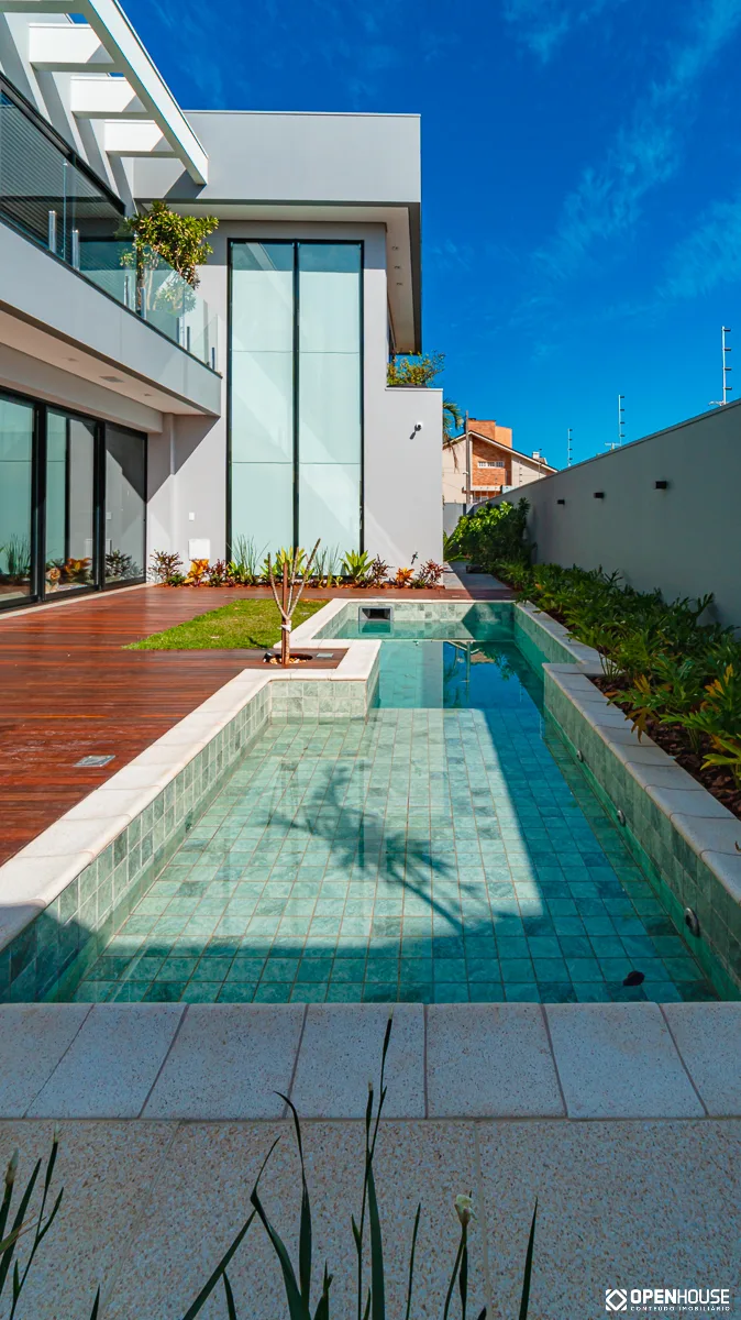 Enquadramento vertical da fachada envidraçada vista a partir da borda da piscina