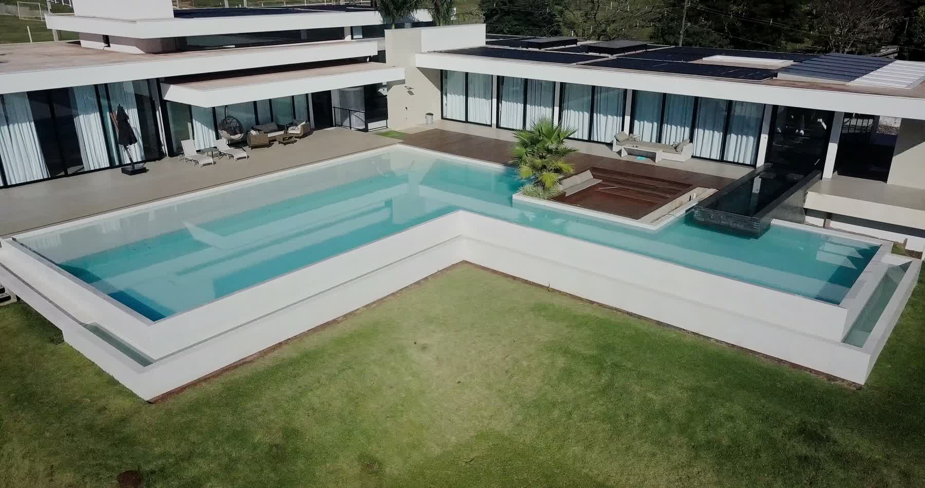 Piscina vista do deck, mostrando a integração entre área externa e a casa