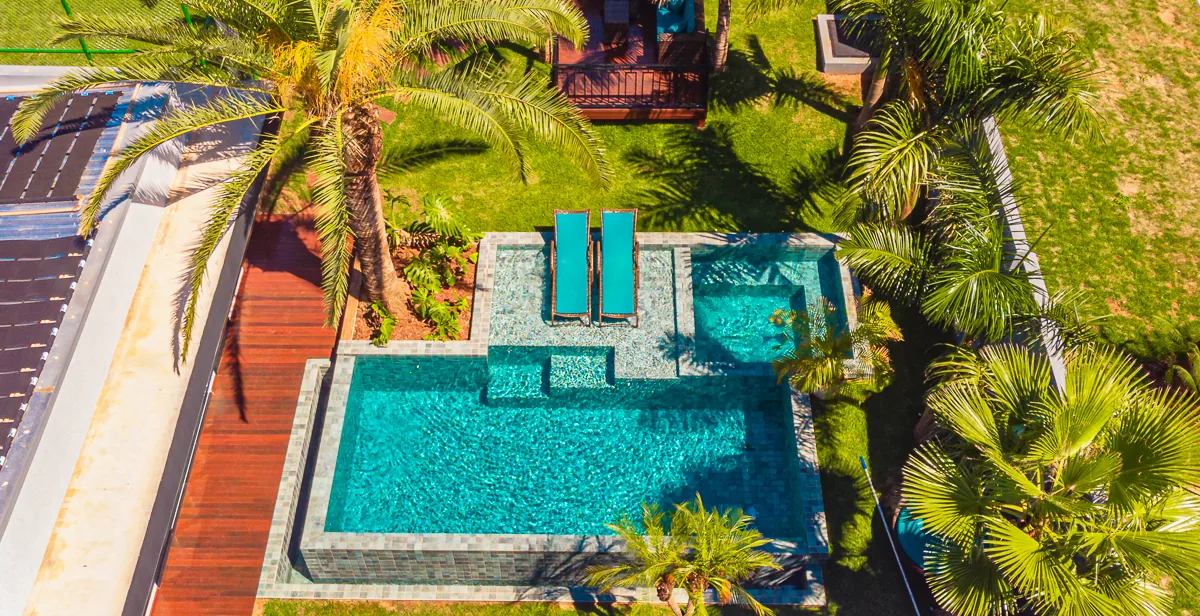Vista aérea do conjunto com piscina, spa, deck de madeira e paisagismo