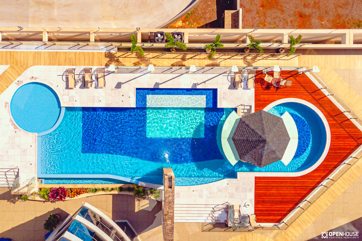 Vista aérea vertical da piscina coletiva, mostrando a lâmina retilínea, a prainha circular e a ilha central coberta