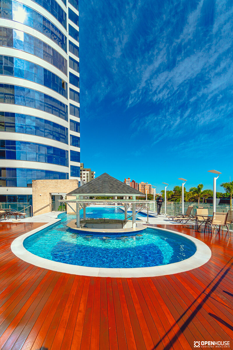 Deck de madeira e prainha circular vistos a partir da base da torre residencial