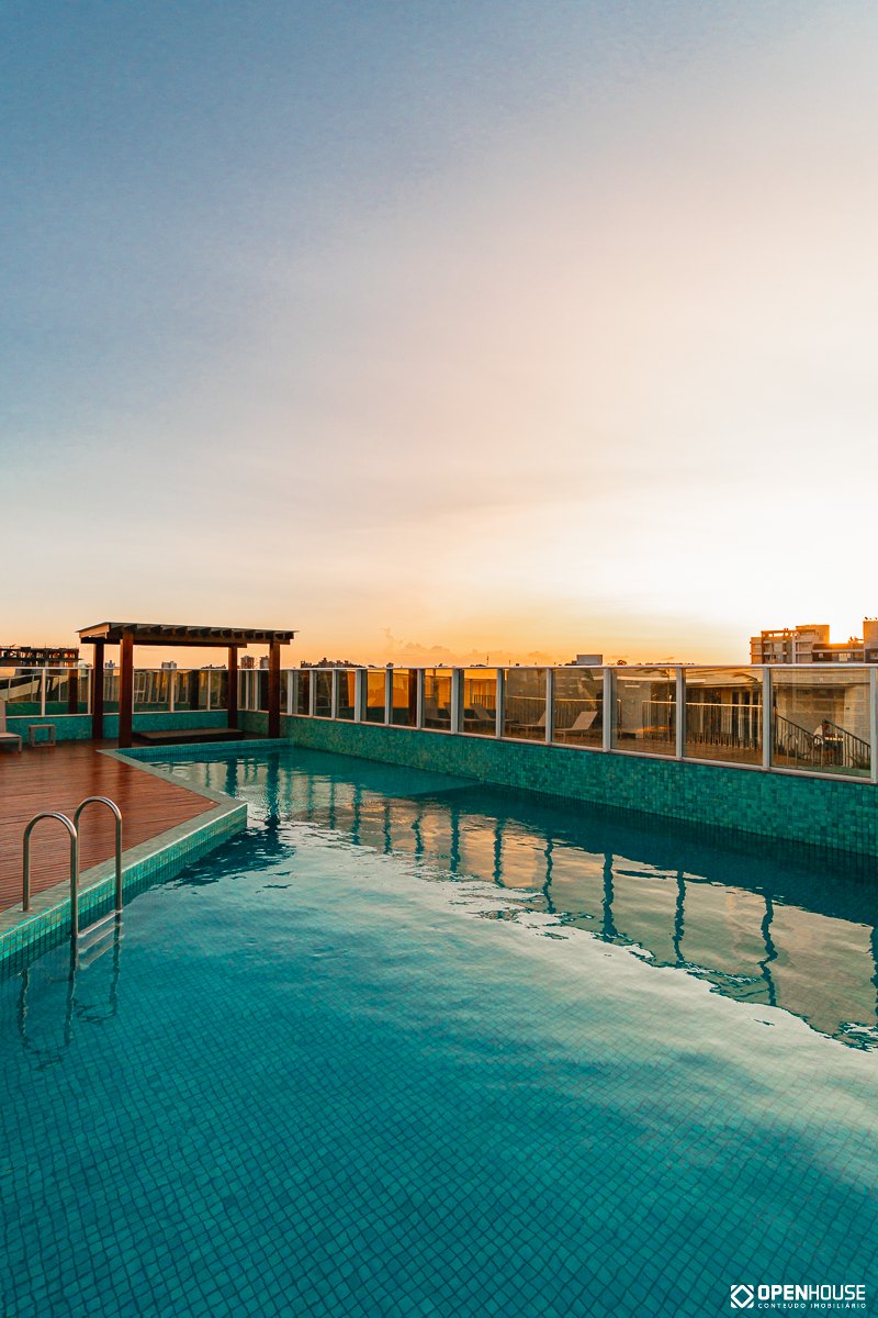 Estrutura vertical do pergolado apoiada no deck, com a piscina em primeiro plano