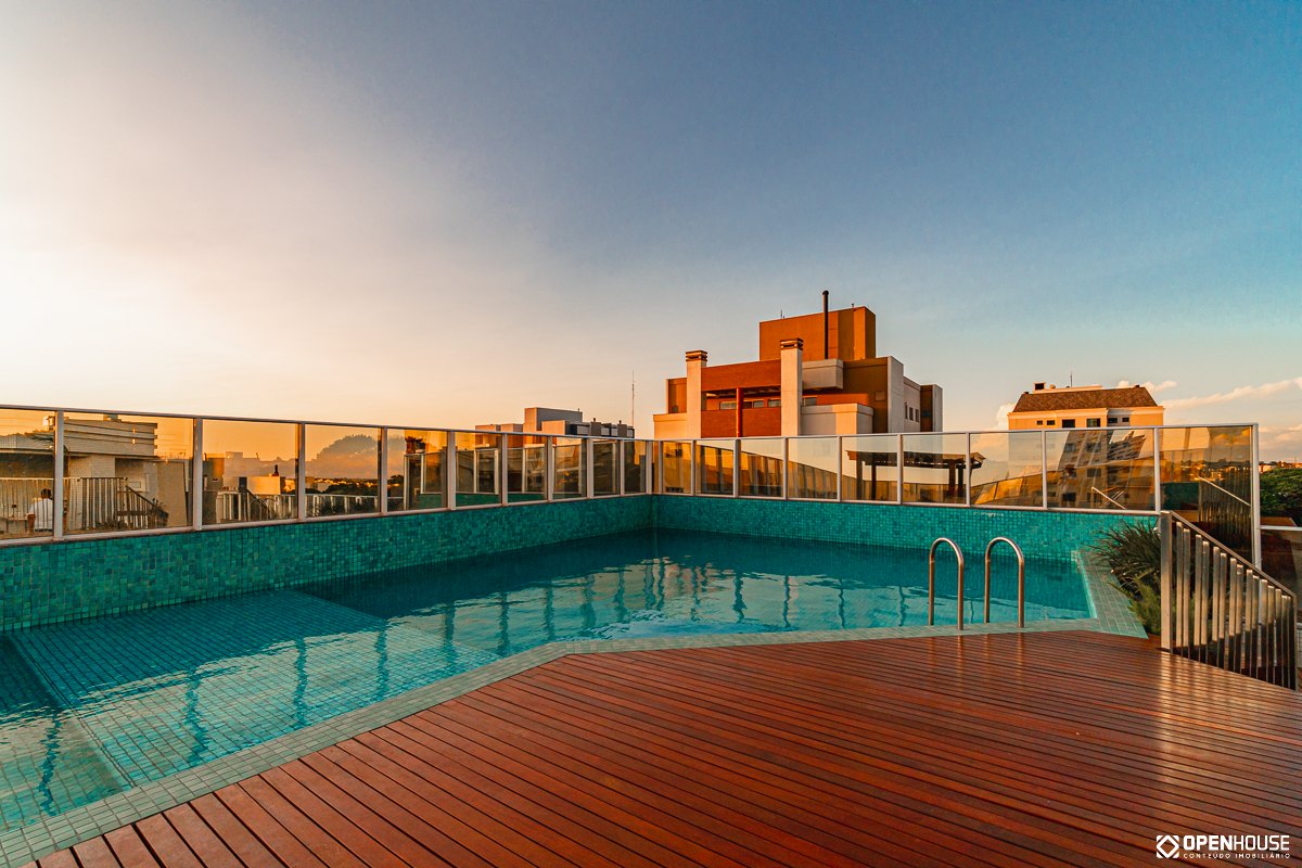 Deck de madeira contínuo envolvendo a piscina, com escada de acesso junto à borda