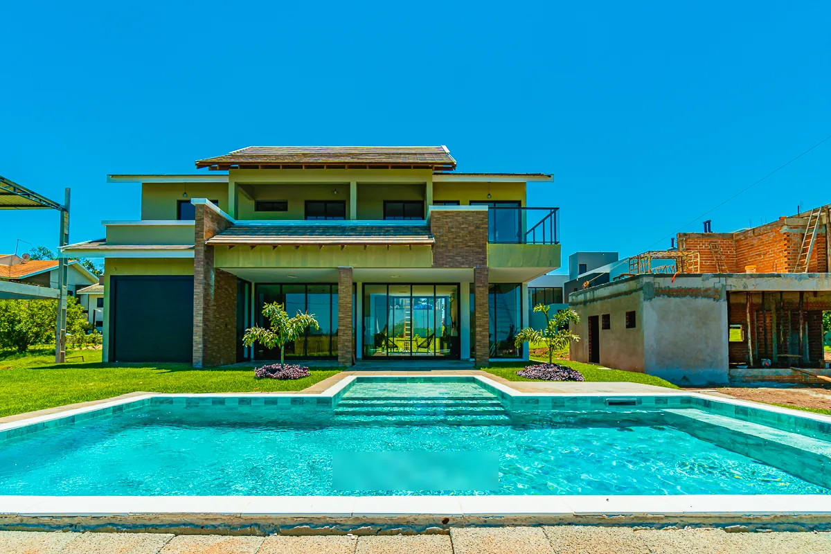 Vista frontal da piscina alinhada ao eixo central da casa, com degraus largos ao centro