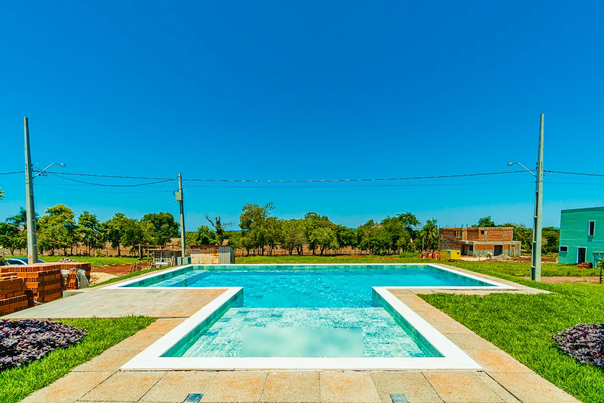 Hidromassagem em primeiro plano conectada à piscina, com o horizonte arborizado ao fundo