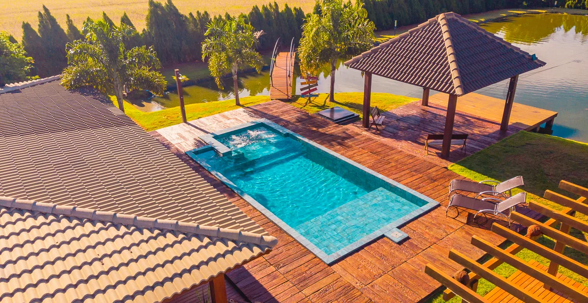 Vista aérea da piscina, do deck e do gazebo voltado para o lago da fazenda