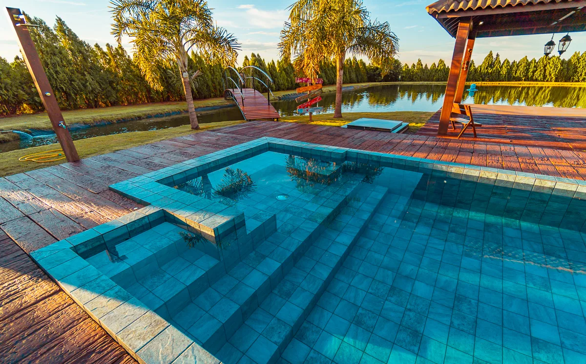 Reflexo do céu na piscina, com o gazebo e o lago ao fundo