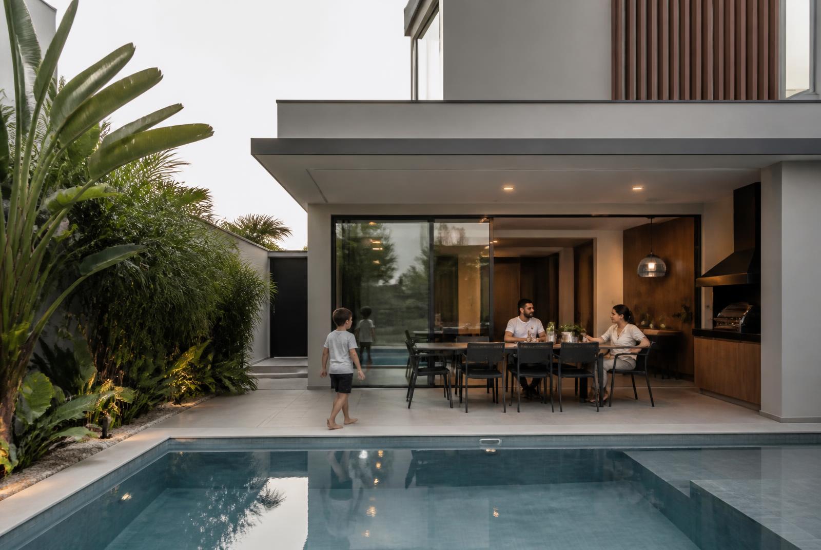 Família usando de maneira espontânea a área externa de uma casa com piscina